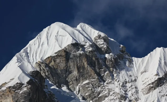 a snowy mountain tops with a cloudy sky