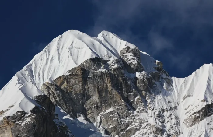 a snowy mountain tops with a cloudy sky