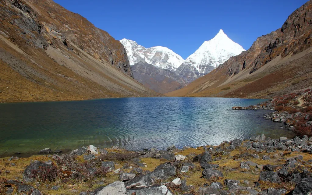 Scenic lake and Himalayan peaks on Jomolhari Trek Bhutan – tranquil waters reflecting snow-capped mountains.