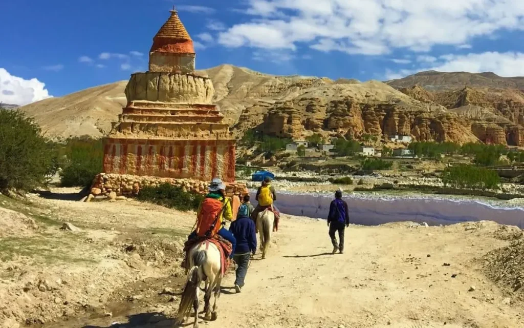 Lomanthang locals riding horses with tourists in the walled city of Upper Mustang, Nepal