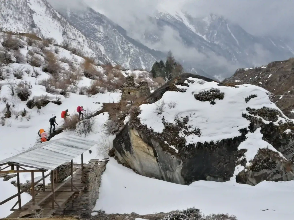 Trekkers walking on a snowy trail during the Manaslu Circuit Group Join Trek in Nepal
