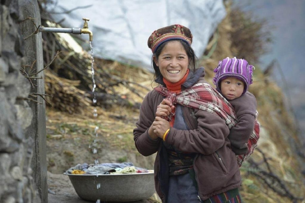 Tamang mother carrying her child in Tap village along the Tamang Heritage Trail