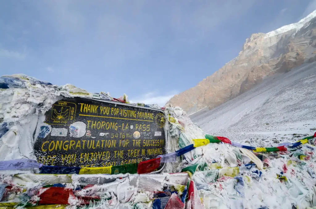 Thorong La Pass board at 5,416 meters on Annapurna Circuit Trek with Tilicho Lake, Nepal
