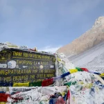 Thorong La Pass board at 5,416 meters on Annapurna Circuit Trek with Tilicho Lake, Nepal