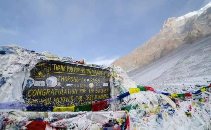 Thorong La Pass board at 5,416 meters on Annapurna Circuit Trek with Tilicho Lake, Nepal