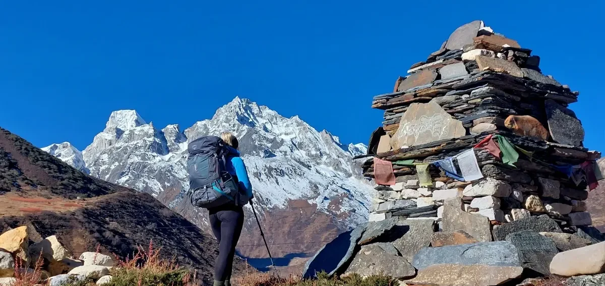 Trekkers hiking along the Tsum Valley Trek trail with panoramic Himalayan mountain views.