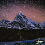 Above snow-capped Himalayan peaks close to Gorakshep on Nepal's Everest Base Camp trail is a starry night sky.
