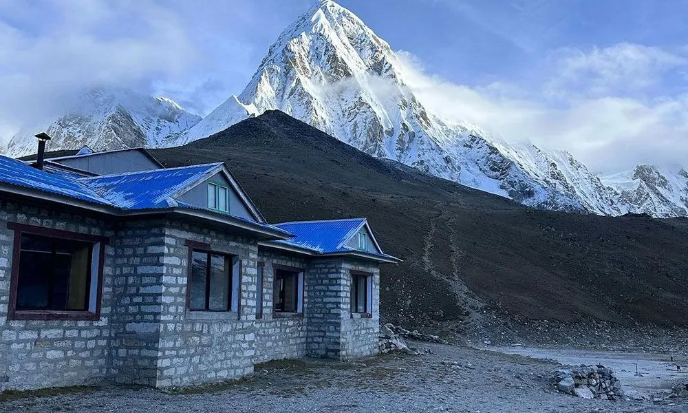 Lodge in Gorakshep, Nepal, close to Everest Base Camp, with snow-capped mountain peaks in the distance.