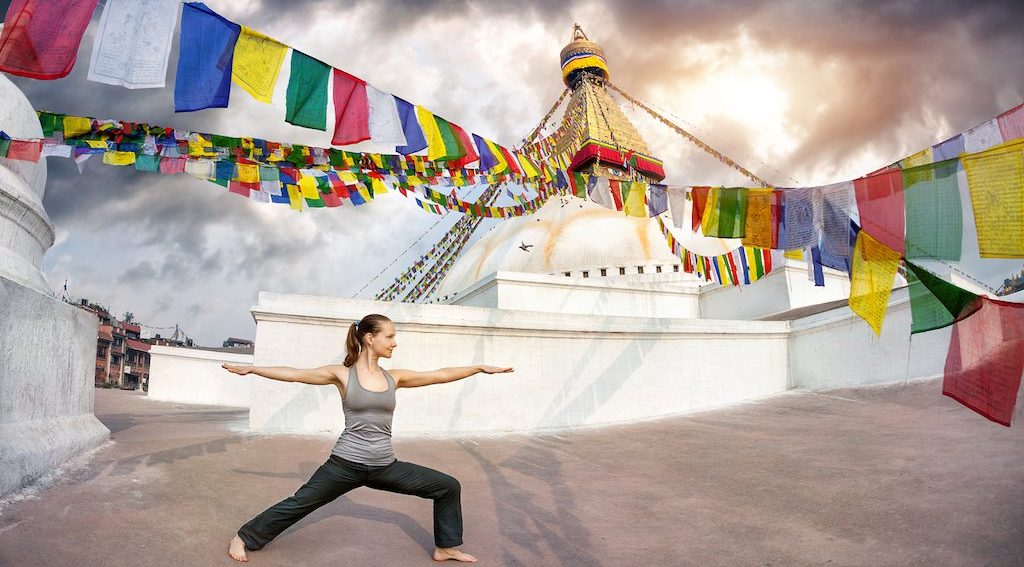 Girl practicing yoga near Boudhanath Stupa at affordable yoga retreats in Nepal