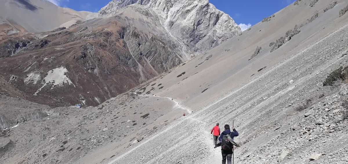 Group of trekkers walking together along a rugged Himalayan trail during one of the challenging treks in Nepal.