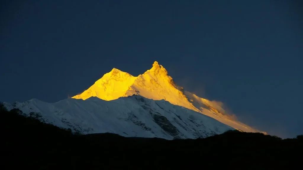 Snow-covered Himalayan mountains rising above deep valleys, showcasing the rugged terrain linked with challenging treks in Nepal.