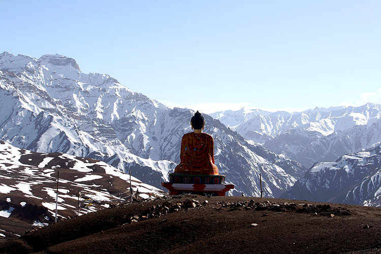 Buddha idol meditating amidst the Himalayan mountains at a Himalayan yoga retreat experience