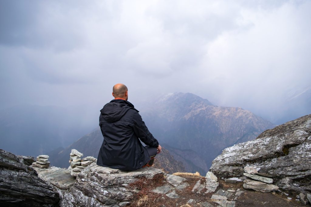 Man meditating in the Himalayas at a Himalayan yoga retreat experience
