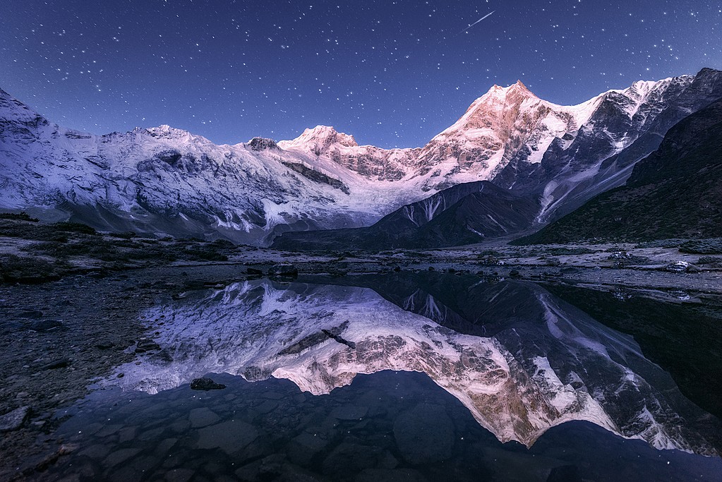 Himalayan mountains at night with starlit sky, perfect for adventure trekking in Nepal