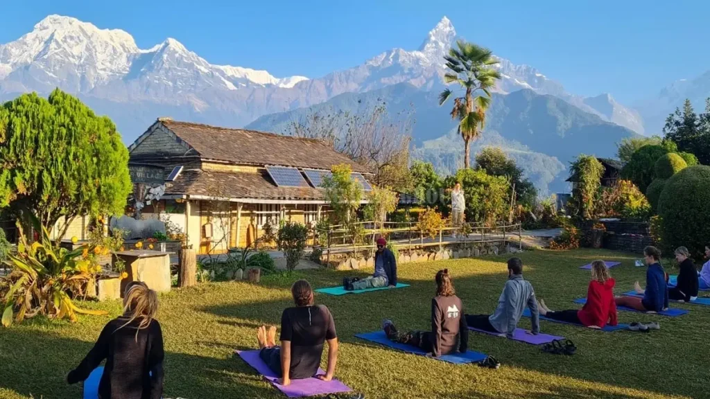 Group of travelers practicing yoga with Himalayan mountain backdrop at a best luxury yoga retreats Nepal experience