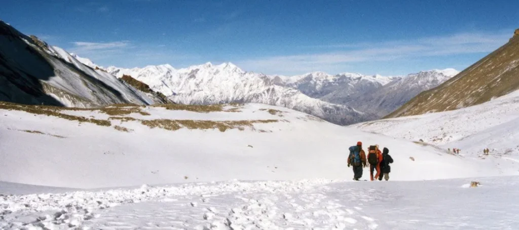 Trekkers walking on a snowy trail during how long is the Annapurna Circuit trek duration journey in Nepal
