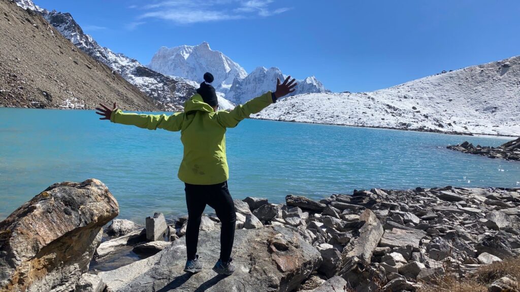 Trekkers posing by a pristine high-altitude lake during Kanchenjunga Circuit Trek, highlighting off-the-beaten-path trekking in Nepal