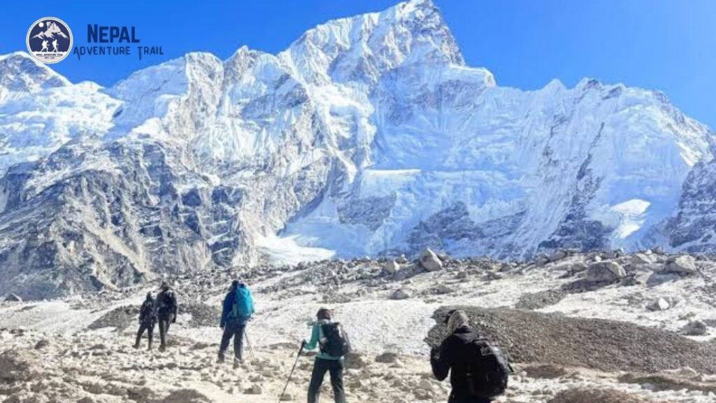 Trekker navigating a high-altitude trail in the Himalayas with the Everest massif in the background during the Nepal Everest Base Camp trek.