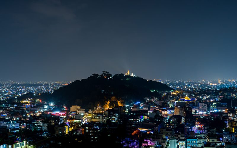Kathmandu city streets illuminated with traditional oil lamps and colorful electric lights during the Tihar festival in Nepal.