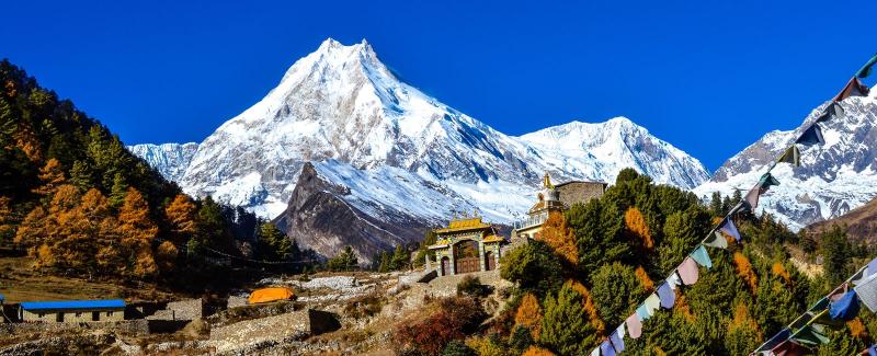 The towering snow and ice mass of Mount Manaslu rising above the Budi Gandaki valley during the Manaslu circuit trek history route.