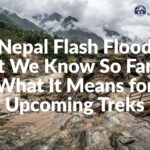 A massive gray debris flow and swollen river cutting through the steep V-shaped valley of the Trishuli river corridor during the Rasuwa flash flood.
