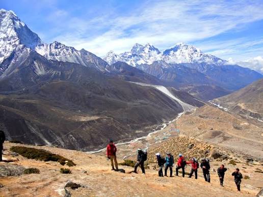 Trekking Start in Nepal with hikers walking along a Himalayan trail surrounded by mountain scenery